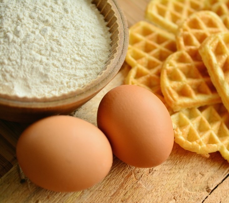 two eggs, bowl of flour, heart-shaped waffles