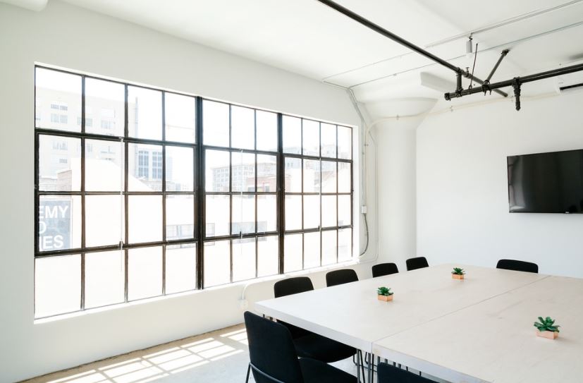 large windows, black chairs, huge white table